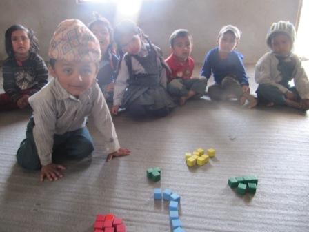Children in Early Years Class Playing with Building Blocks and Counters